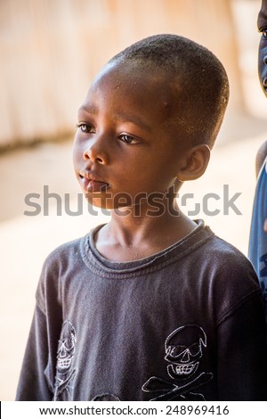 LOME, TOGO - MAR 9, 2013: Unidentified Togolese boy thinks of something. People of Togo suffer of poverty due to the unstable economic situation.