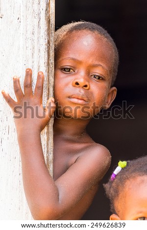 KARA, TOGO - MAR 9, 2013: Unidentified Togolese girl opens the door the door. People in Togo suffer of poverty due to the unstable econimic situation