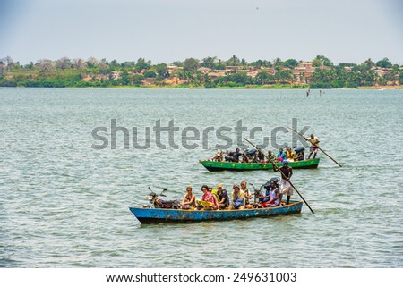 KARA, TOGO - MAR 9, 2013: Unidentified Togolese people and tourists on a boat. Children in Togo suffer of poverty due to the unstable econimic situation