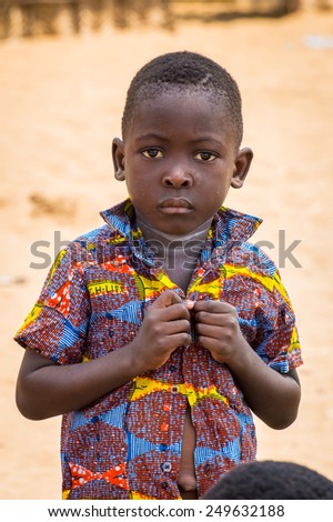 KARA, TOGO - MAR 9, 2013: Unidentified Togolese boy wears a shirt with buttons. People in Togo suffer of poverty due to the unstable econimic situation