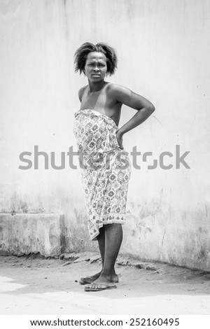 LOME, TOGO - MAR 9, 2013: Unidentified Togolese woman wears a light African dress. People of Togo suffer of poverty due to the unstable economic situation.