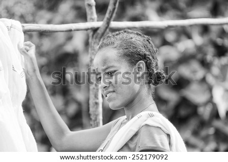 OMO, ETHIOPIA - SEPTEMBER 20, 2011: Unidentified Ethiopian beautiful girl hangs the clothes to dry. People in Ethiopia suffer of poverty due to the unstable situation
