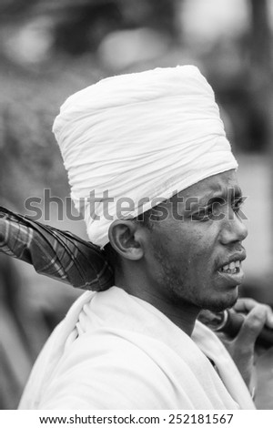 OMO VALLEY, ETHIOPIA - SEP 22, 2011: Unidentified Ethiopian man in white turban carries the umbrella in Ethiopia, Sep.22, 2011. People in Ethiopia suffer of poverty due to the unstable situation