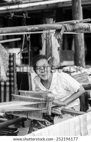 LUANG PRABANG, LAOS - SEP 25, 2014: Unidentified Lao woman sews outdoors. 55% of Laos people belong to the Lao ethnic group
