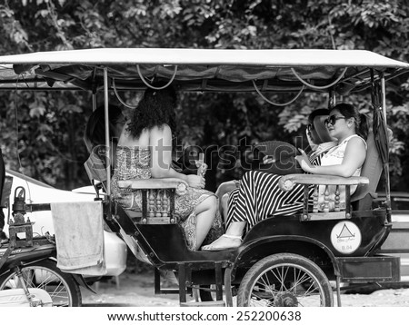 ANGKOR THOM, CAMBODIA - SEP 27, 2014: Unidentified tourists in a local taxi cab at Angkor Thom. Angkor Thom was the last capital city of the Khmer empire