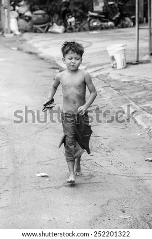 SIEM RIEP, CAMBODIA - SEP 28, 2014: Unidentified Khmer cute boy runs in Siem Reap. 90% of Cambodian people belong to Khmer etnic group