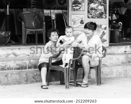 HO CHI MINH, VIETNAM - SEP 20, 2014: Unidentified Vietnamese family with a little baby on the chair. 90% of Vietnamese people belong to the Viet ethnic group