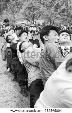 NORTH KOREA - MAY 1, 2012: Korean people participating in the tug of war game during the celebration of the International Worker\'s Day in N.Korea, May 1. May 1 is a national holiday in 80 countries
