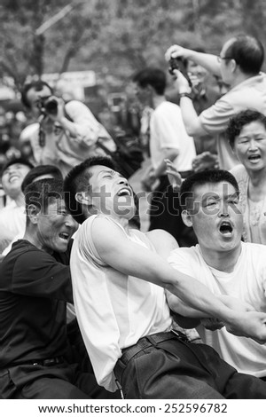 NORTH KOREA - MAY 1, 2012: Korean woman emotionally participates in the tug of war game during the celebration of the Worker\'s Day in N.Korea, May 1, 2012. May 1 is a national holiday in 80 countries