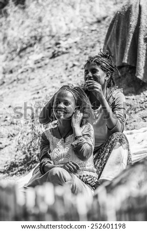 OMO, ETHIOPIA - SEPTEMBER 21, 2011: Unidentified Ethiopian woman makes haircut. People in Ethiopia suffer of poverty due to the unstable situation