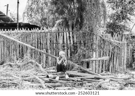 OMO, ETHIOPIA - SEPTEMBER 19, 2011: Unidentified Ethiopian boy sits on wooden sticks.  People in Ethiopia suffer of poverty due to the unstable situation