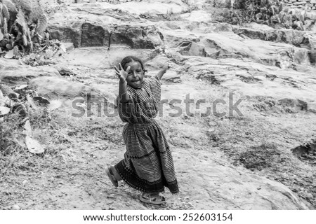 OMO, ETHIOPIA - SEPTEMBER 21, 2011: Unidentified Ethiopian girl runs in the street. People in Ethiopia suffer of poverty due to the unstable situation