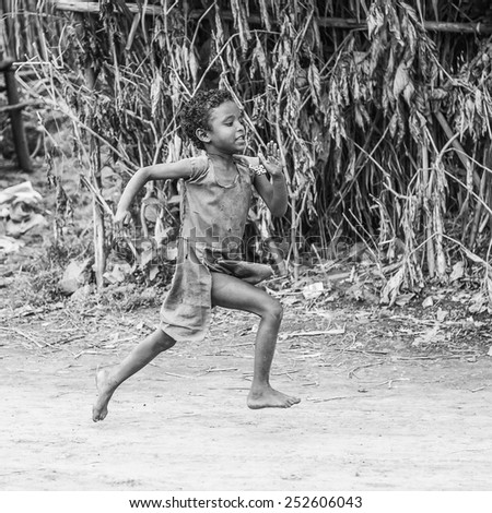 OMO, ETHIOPIA - SEPTEMBER 19, 2011: Unidentified Ethiopian girl runs happily. People in Ethiopia suffer of poverty due to the unstable situation