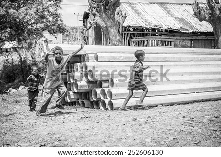 OMO, ETHIOPIA - SEPTEMBER 21, 2011: Unidentified Ethiopian children run in the street. People in Ethiopia suffer of poverty due to the unstable situation