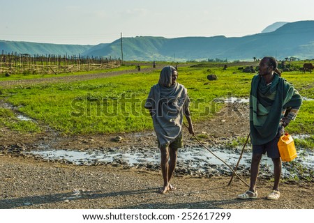 OMO, ETHIOPIA - SEPTEMBER 19, 2011: Unidentified Ethiopian men with sticks in the field. People in Ethiopia suffer of poverty due to the unstable situation