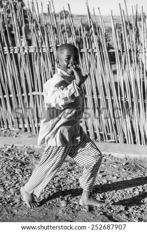 ANTANANARIVO, MADAGASCAR - JULY 3, 2011: Unidentified Madagascar boy runs happily in the street. People in Madagascar suffer of poverty due to slow development of the country