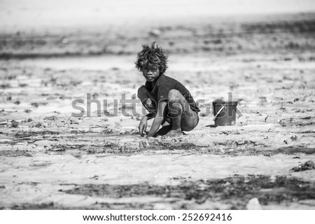 ANTANANARIVO, MADAGASCAR - JULY 3, 2011: Unidentified Madagascar boy plays with sand. People in Madagascar suffer of poverty due to slow development of the country