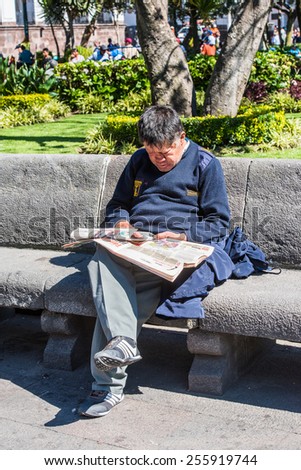 QUITO, ECUADOR - JAN 2, 2015: Unidentified Ecuadorian man reads a newspaper. 71,9% of Ecuadorian people belong to the Mestizo ethnic group