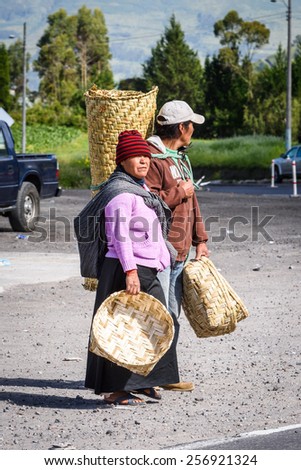 OTAVALO, ECUADOR - JAN 7, 2015: Unidentified Ecuadorian man and woman go to the market with backets. 71,9% of Ecuadorian people belong to the Mestizo ethnic group