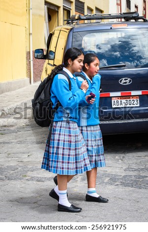 RIOBAMBA, ECUADOR - JAN 7, 2015: Unidentified Ecuadorian school girls walk in the street. 71,9% of Ecuadorian people belong to the Mestizo ethnic group