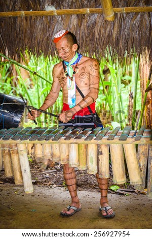 YASUNI, ECUADOR - JAN 4, 2015:  Unidentified Ecuadorian indian makes music. Indigenous indians  are protected by COICA (Coordinator of Indigenous Organizations of the Amazon River Basin)