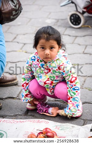 OTAVALO, ECUADOR - JAN 3, 2015: Unidentified Ecuadorian little girl plays with barbie at the Otavalo Market. 71,9% of Ecuadorian people belong to the Mestizo ethnic group