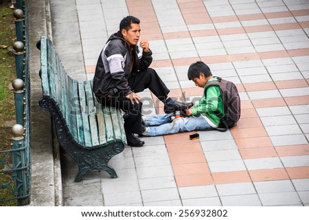 CUENCA, ECUADOR - JAN 9, 2015: Unidentified Ecuadorian boy cleans shoes. 71,9% of Ecuadorian people belong to the Mestizo ethnic group
