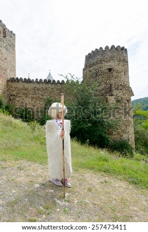 ANANURI, GEORGIA - JULY 22, 2014: Unidentified little girl wearing the traditional costume of the shepherd. This way the Georgian shepherd were look like