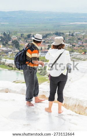 PAMUKKALE, TURKEY - APR 18, 2015: Unidentified tourist  in a hat on the travertines of Pamukkale, Turkey. It's a UNESCO World Heritage site