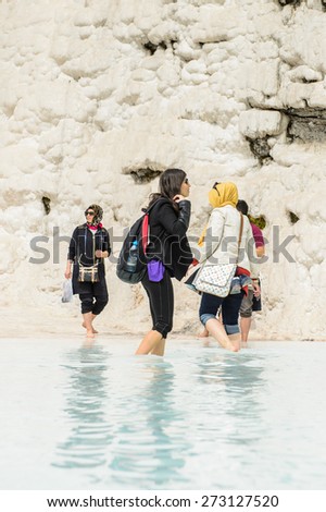 PAMUKKALE, TURKEY - APR 18, 2015: Unidentified tourists in a hot spring on the travertines of Pamukkale, Turkey. It\'s a UNESCO World Heritage site