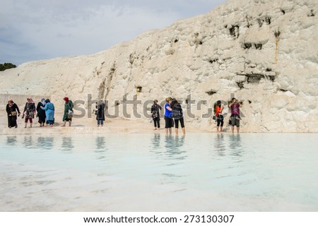 PAMUKKALE, TURKEY - APR 18, 2015: Unidentified tourists in a hot spring on the travertines of Pamukkale, Turkey. It\'s a UNESCO World Heritage site