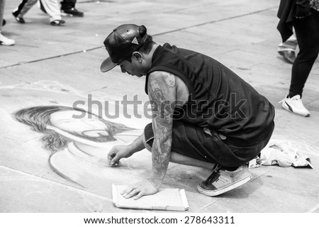 SANTIAGO, CHILE - NOV 1, 2014:  Unidentified Chilean man draws a Jesus Christ image on the ground in Santiago. Chilean people are mainly of mixed Spanish and Amerindian descent