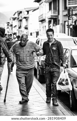 CUENCA, ECUADOR - JAN 9, 2015: Unidentified Ecuadorian man help to the old man to walk. 71,9% of Ecuadorian people belong to the Mestizo ethnic group