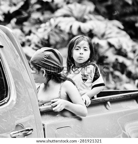 MINDO, ECUADOR - JAN 1, 2015: Unidentified Ecuadorian little girls in a back of the car. 71,9% of Ecuadorian people belong to the Mestizo ethnic group