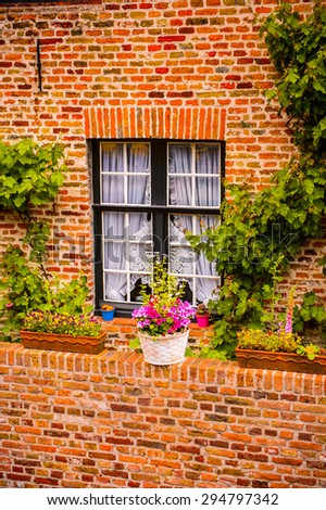 Medieval houses with flowers at the windows in the Historic Centre of Bruges, Belgium. part of the UNESCO World Heritage site