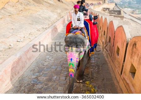 JAIPUR, INDIA - JAN 19, 2016: Unidentified tourists ride an elephant. Indian elephants used to be one of the main way of transportation in the past