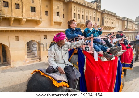 JAIPUR, INDIA - JAN 19, 2016: Unidentified Indian man rides an elephant with tourists. Indian elephants used to be one of the main way of transportation in the past