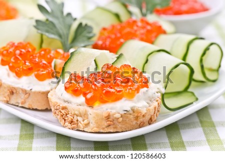 Sandwiches with red caviar, cucumber and cream cheese