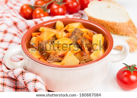 Stewed potatoes with meat, carrots and tomatoes