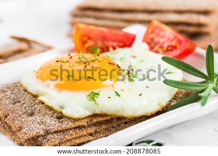Fried egg on crisp bread and tomatoes.