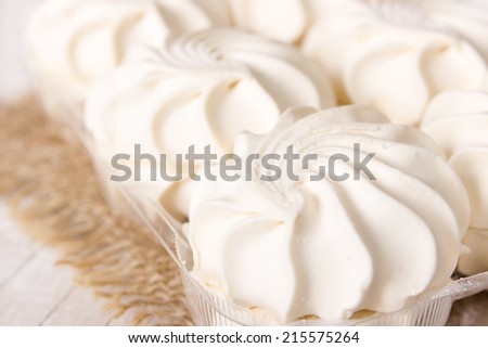 Sweet vanilla marshmallows in the packing on wooden background