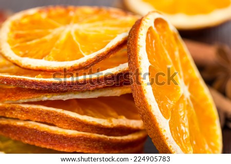 Slices of dried orange, cinnamon and star anise on a wooden background.