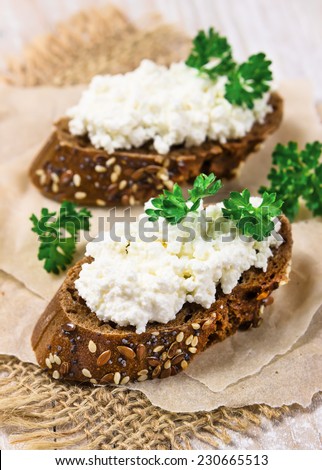 Two sandwich from rye bread with curd cheese and parsley.