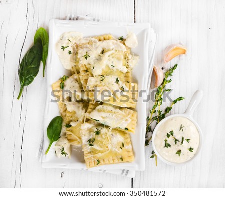 Ravioli with spinach and ricotta cheese with white sauce and grated Parmesan