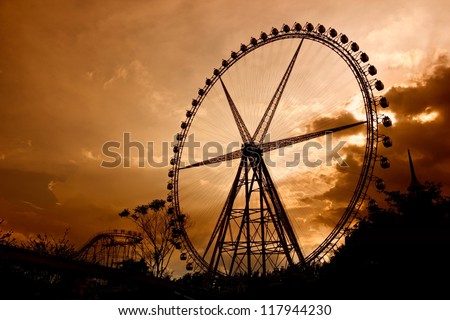 Ferris Wheel at sunset. Some Chinese words in the photo mean roller coaster and not an ad.