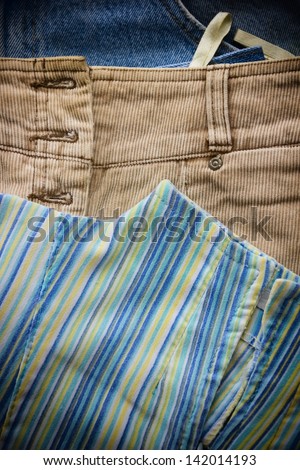 Close-up of women\'s shirt, skirt and blue jeans.