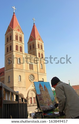TSINGTAO, CHINA - NOVEMBER 15: An artist is painting the famous church on his board on November 15, 2013 in Tsingtao, China.