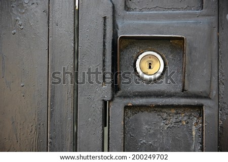 Close up of lock on black iron door.