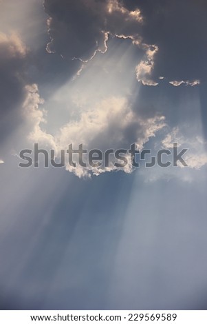 Beam of sunlight through clouds background.
