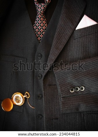 Men\'s black suit with golden pocket watch.